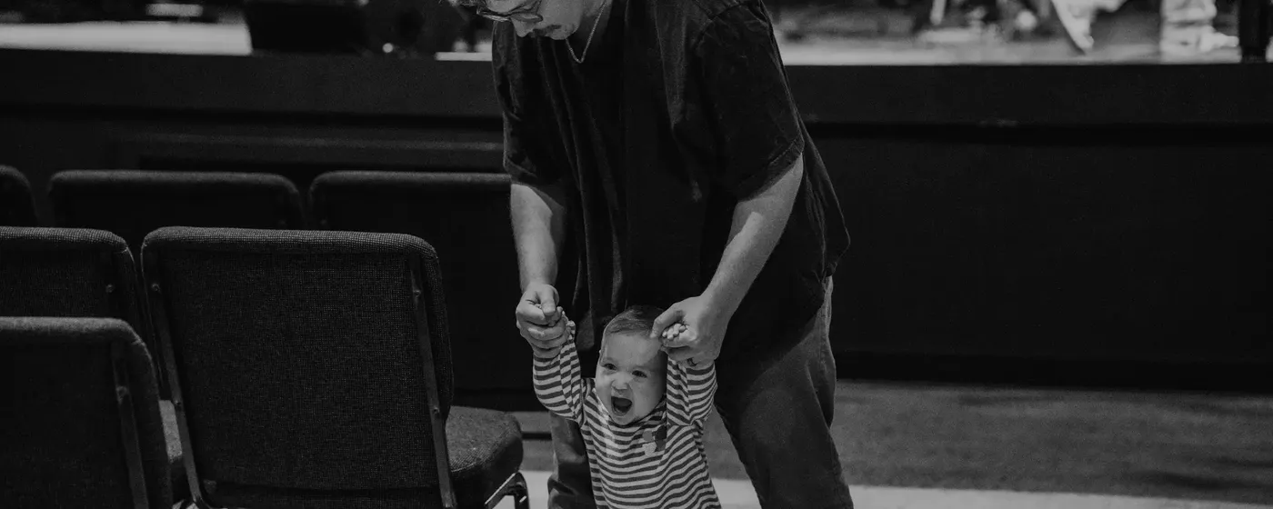 Man walking baby down aisle at Church