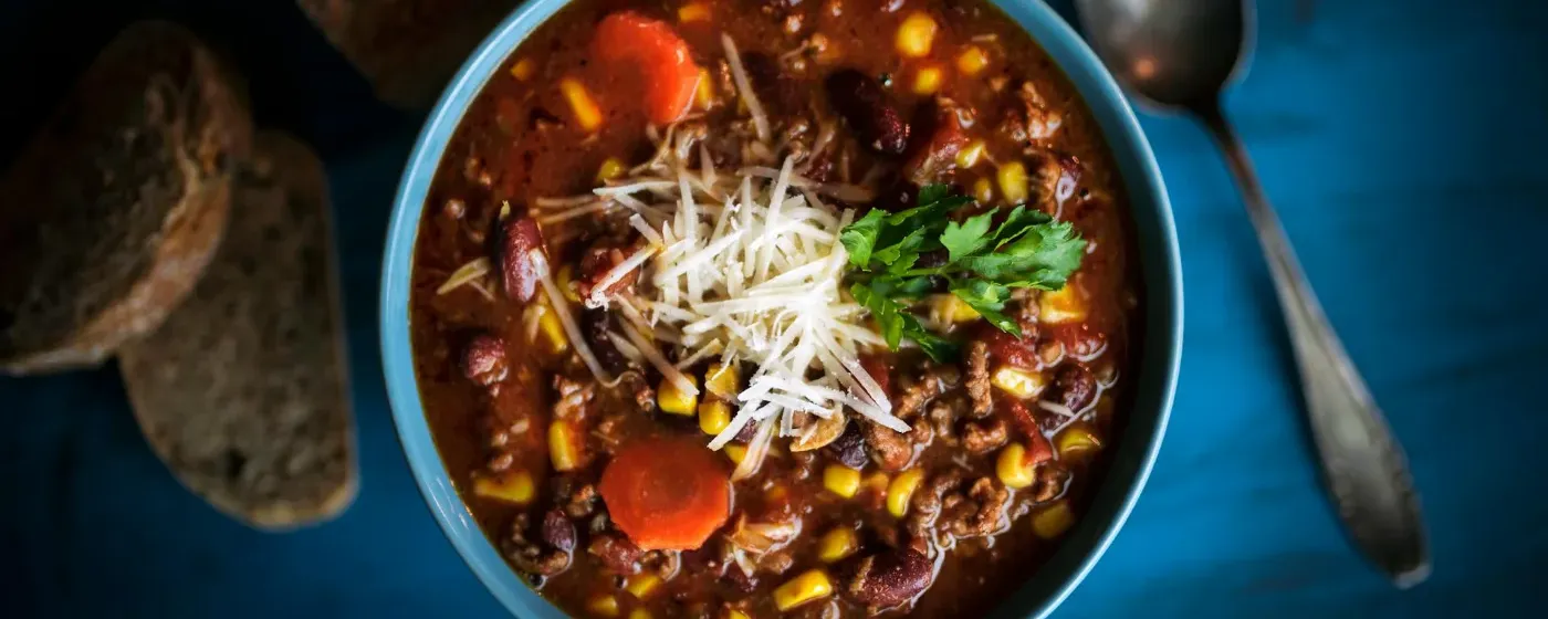 Bowl of chili with spoon and bread